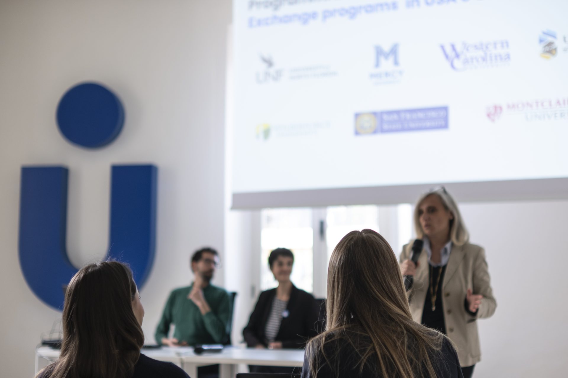 A briefing on Unicollege exchange programs, with partner-university logos on screen