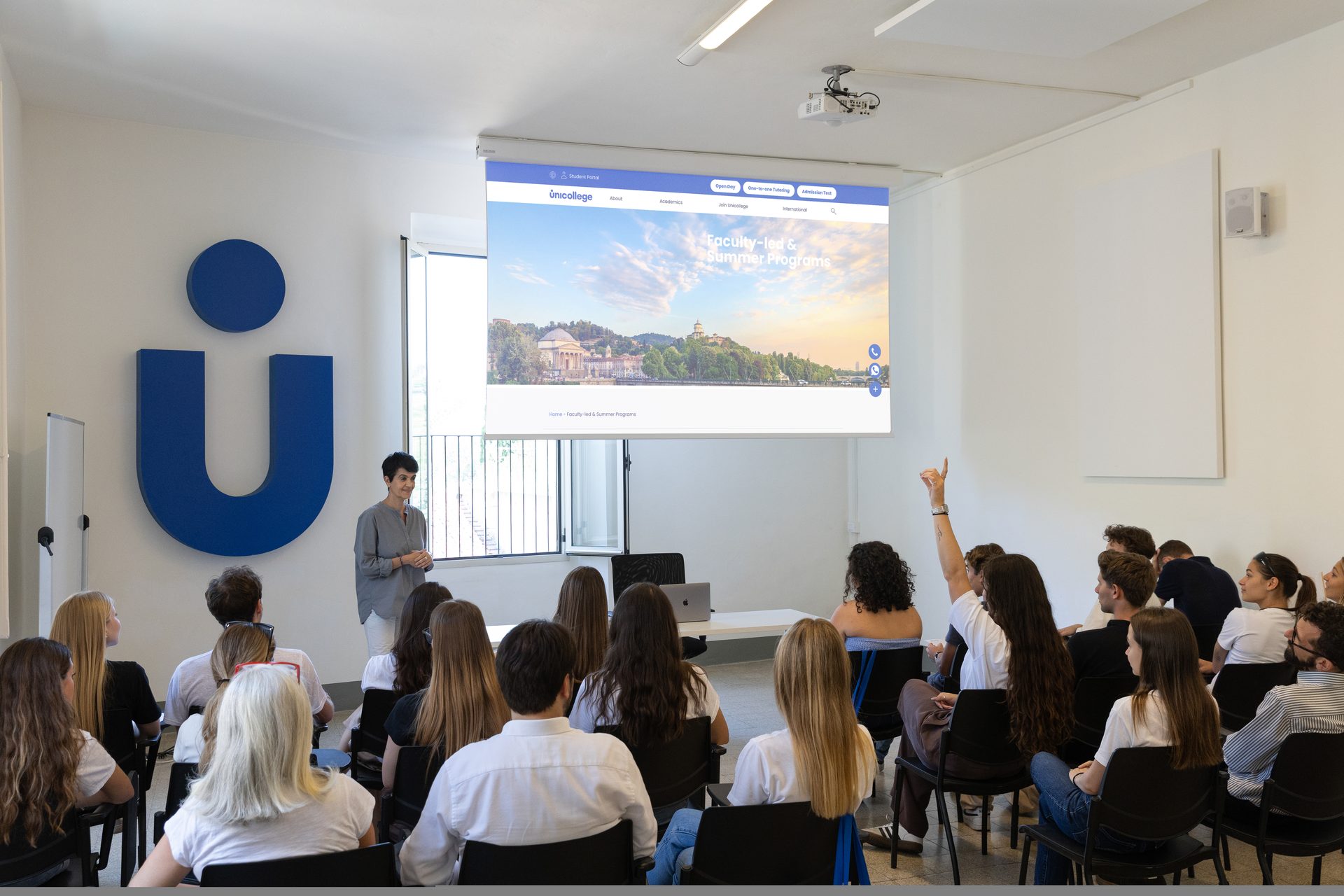An orientation session at Unicollege, a student raising her hand to ask a question