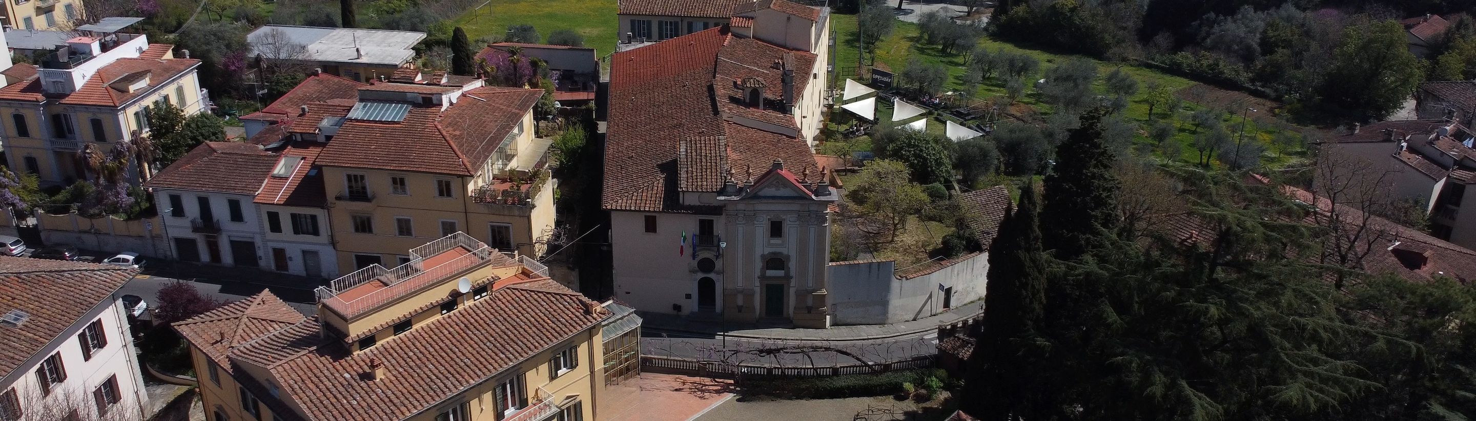 The entrance church and the yellow villa of the Florence campus in the sunlight