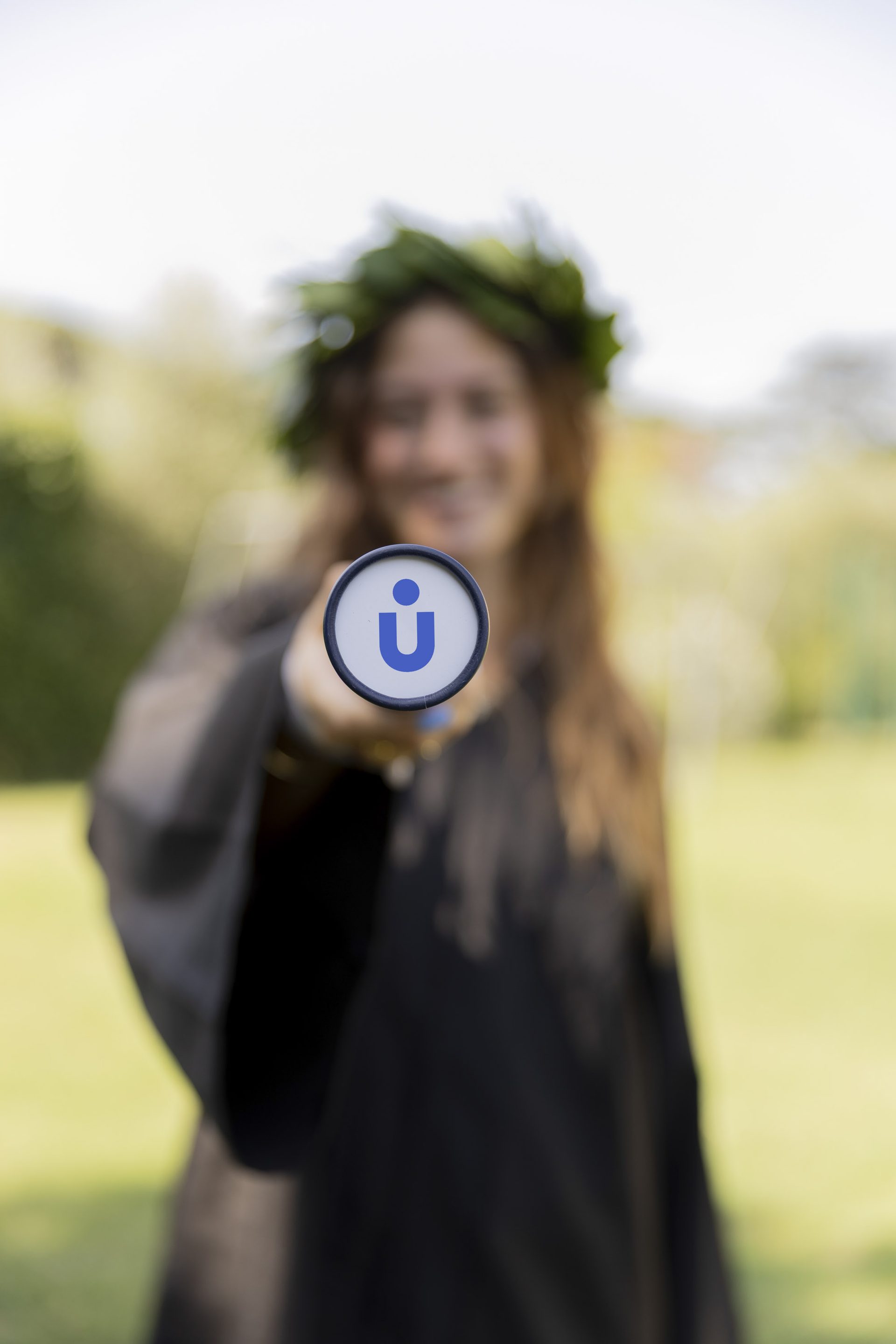 A Unicollege graduate holding the University pin on graduation day