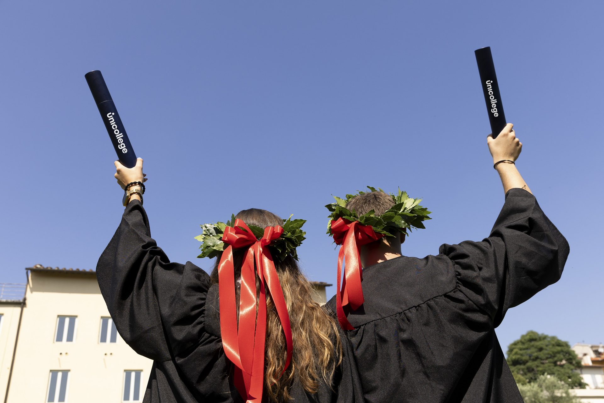 Unicollege graduates celebrating with the traditional Italian laurel wreath