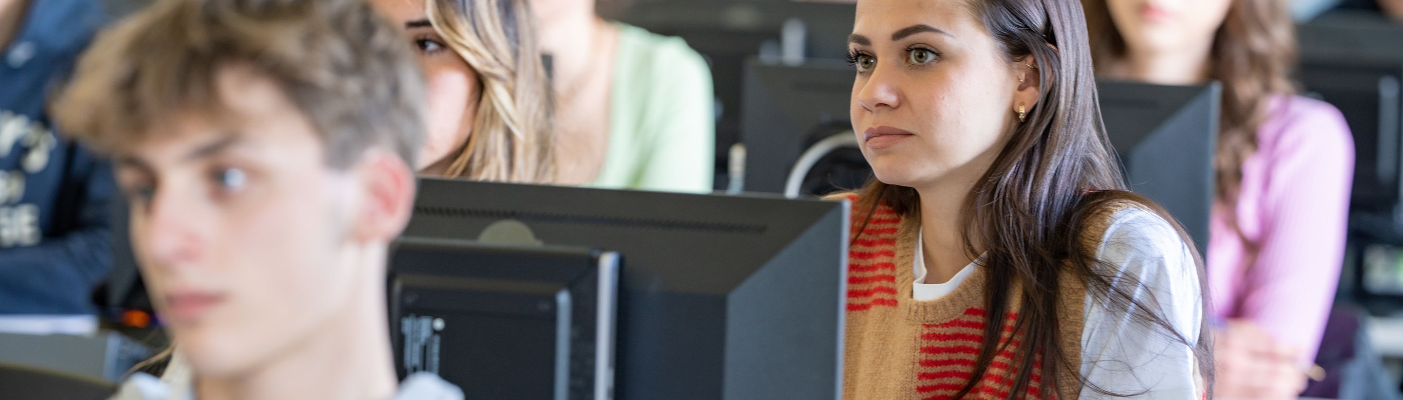 Students listening during a lesson in the Unicollege computer lab