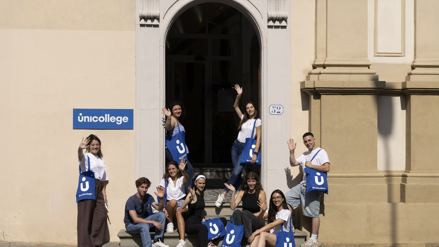Unicollege students with flags at the campus entrance