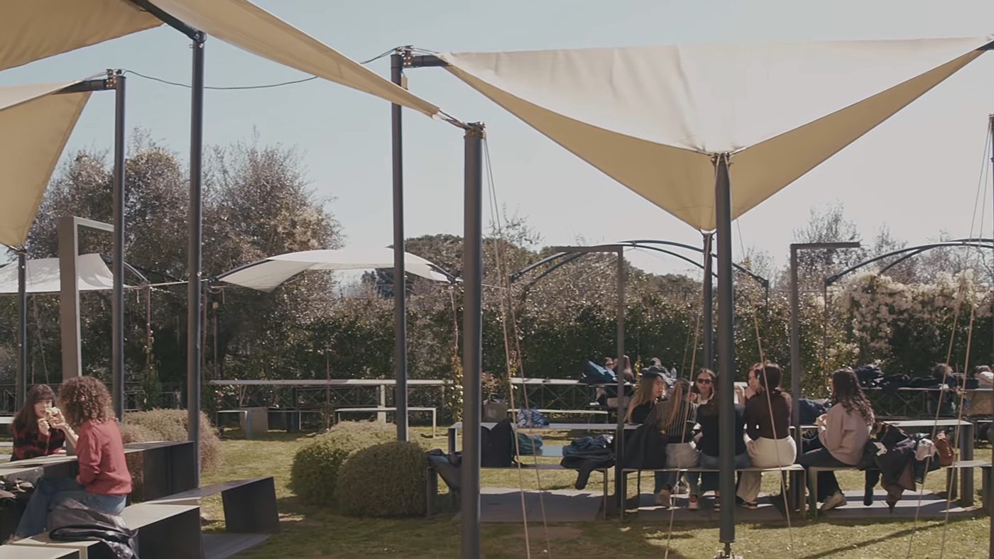 Students at the tables under the tents in the garden of the Florence campus
