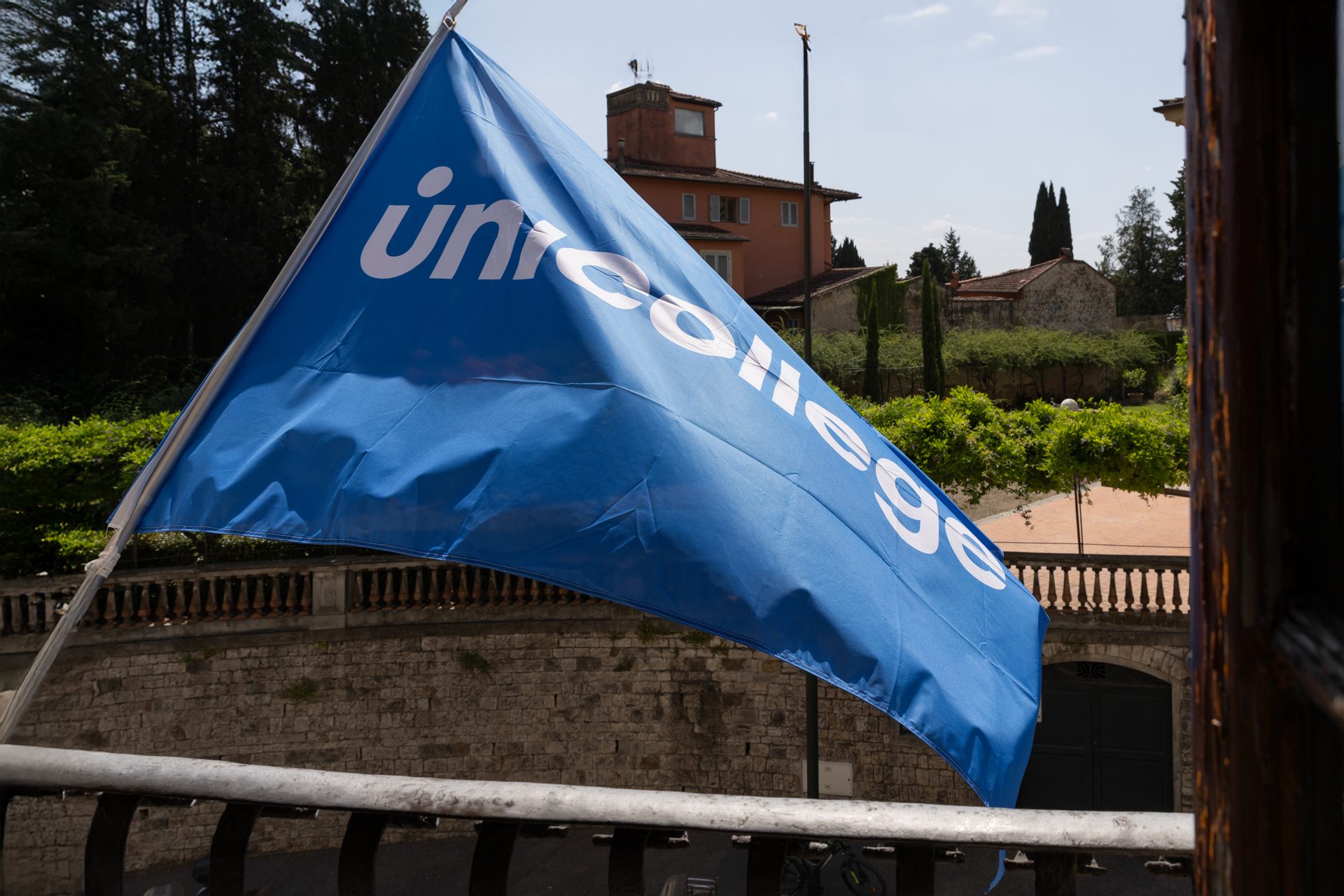 The Unicollege flag flying over the Tuscan hills at the Florence Headquarters